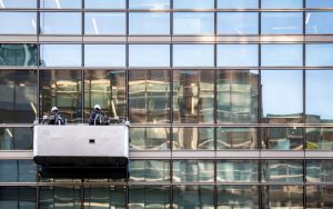 Two men cleaning the exterior windows of a commercial building.
